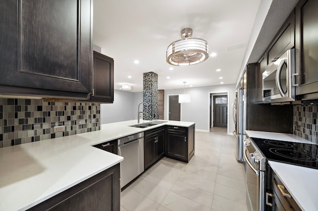 8954 Chatsworth Dr, Houston, TX 77024 - kitchen with a sink, stainless steel appliances, a peninsula, decorative backsplash, and light countertops