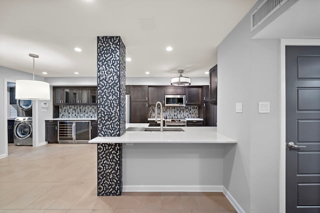 8954 Chatsworth Dr, Houston, TX 77024 - kitchen with stainless steel microwave, a sink, backsplash, dark brown cabinets, and recessed lighting