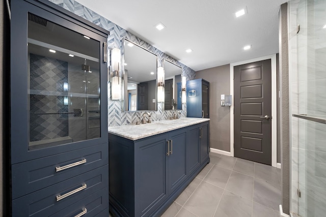 8954 Chatsworth Dr, Houston, TX 77024 - full bathroom featuring a stall shower, baseboards, tasteful backsplash, double vanity, and tile patterned flooring