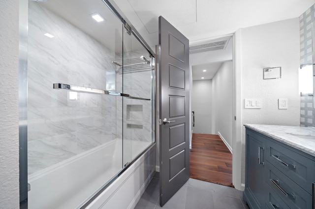 8954 Chatsworth Dr, Houston, TX 77024 - bathroom featuring vanity, shower / bath combination with glass door, tile patterned flooring, and baseboards