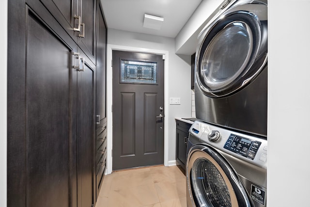 8954 Chatsworth Dr, Houston, TX 77024 - clothes washing area featuring stacked washer and clothes dryer, cabinet space, baseboards, and light tile patterned flooring
