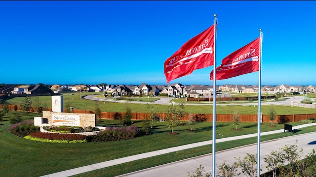 view of property's community with a yard, fence, and a residential view