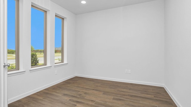 spare room featuring dark wood-type flooring, baseboards, and recessed lighting