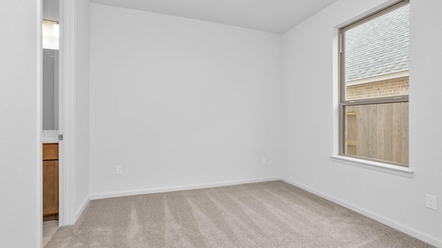 carpeted empty room featuring baseboards