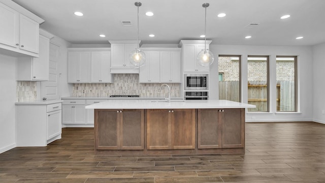 kitchen with a sink, stainless steel appliances, dark wood-style floors, backsplash, and recessed lighting