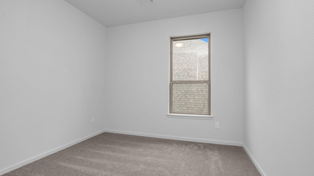 empty room featuring carpet and baseboards