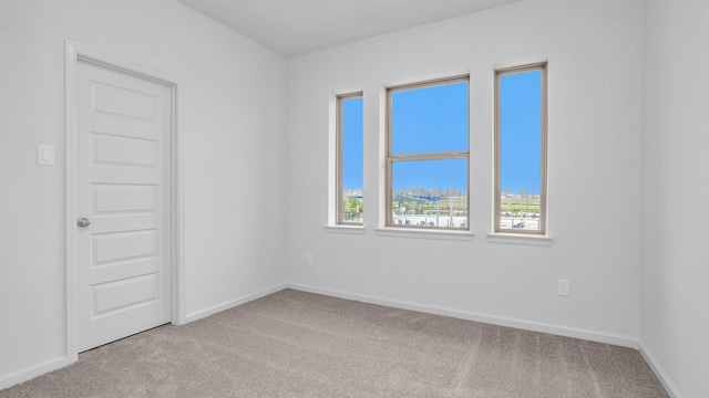 carpeted spare room with baseboards