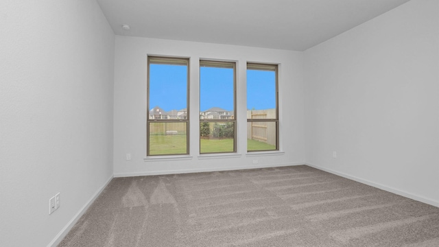 unfurnished room with carpet floors and baseboards