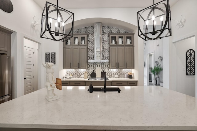 2514 Heritage Park Dr, Missouri City, TX 77459 - kitchen featuring light stone countertops, a notable chandelier, decorative backsplash, and a sink