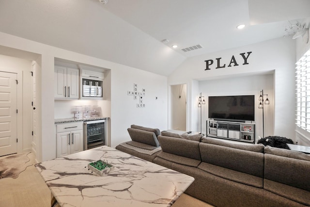 2514 Heritage Park Dr, Missouri City, TX 77459 - living room with lofted ceiling, visible vents, indoor wet bar, light carpet, and wine cooler