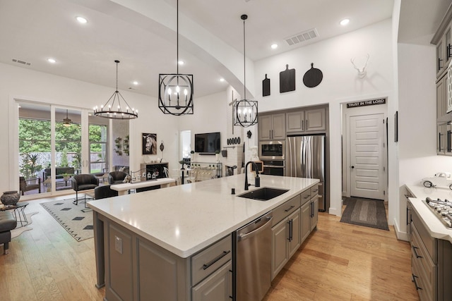 2514 Heritage Park Dr, Missouri City, TX 77459 - kitchen featuring appliances with stainless steel finishes, visible vents, gray cabinetry, a chandelier, and open floor plan