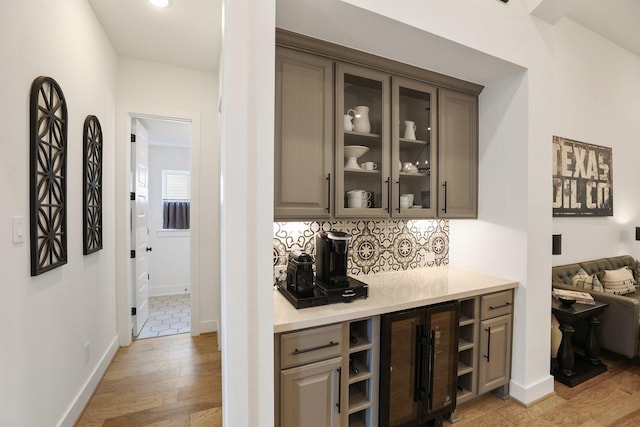 2514 Heritage Park Dr, Missouri City, TX 77459 - bar featuring baseboards, light wood-style flooring, and tasteful backsplash