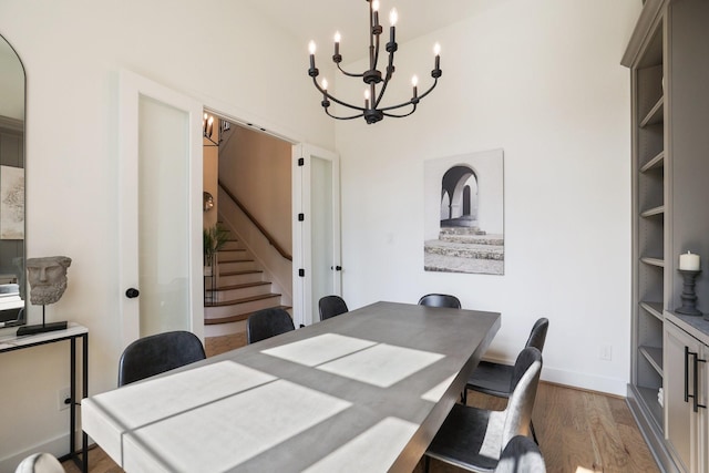 2514 Heritage Park Dr, Missouri City, TX 77459 - dining space with stairway, wood finished floors, a chandelier, and baseboards