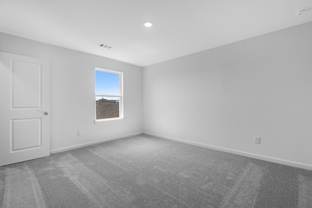 carpeted spare room featuring baseboards, visible vents, and recessed lighting