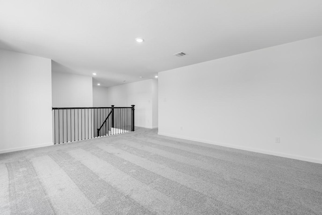 carpeted spare room with baseboards, visible vents, and recessed lighting