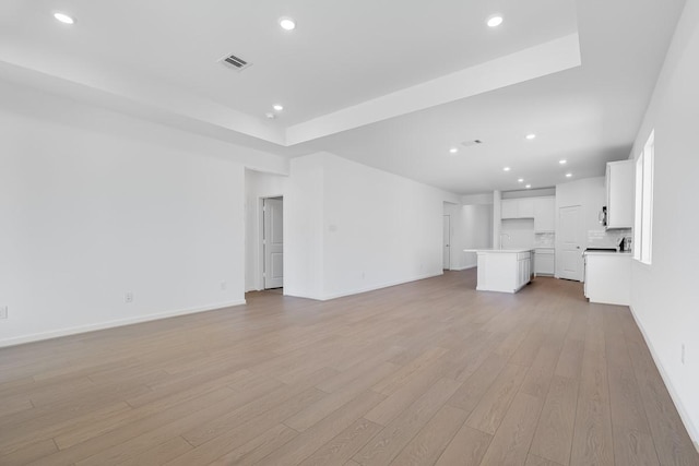 unfurnished living room featuring baseboards, visible vents, light wood finished floors, and recessed lighting