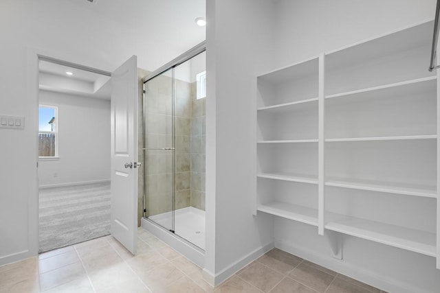 full bathroom featuring recessed lighting, baseboards, tile patterned flooring, and a stall shower