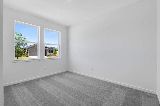 carpeted spare room featuring baseboards