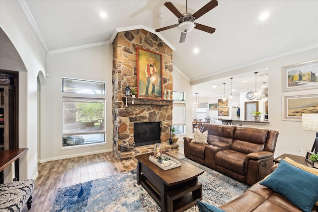 3650 Ward Bend Rd, Sealy, TX 77474 - living area with crown molding, ceiling fan, arched walkways, a stone fireplace, and wood finished floors