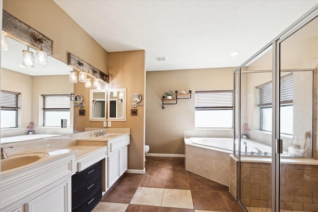 3650 Ward Bend Rd, Sealy, TX 77474 - bathroom featuring a sink, double vanity, toilet, visible vents, and a garden tub