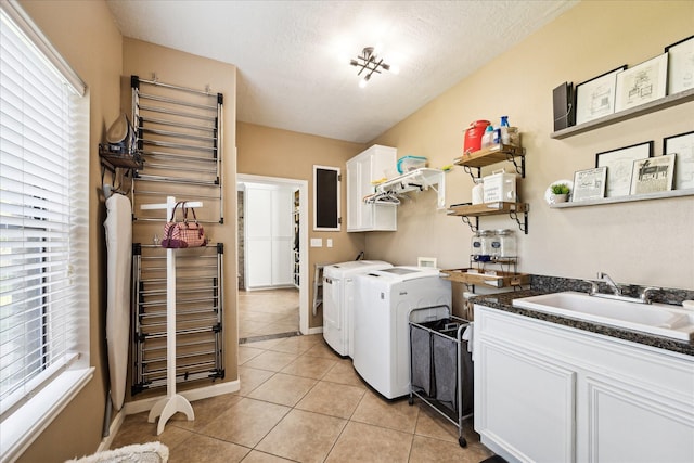 3650 Ward Bend Rd, Sealy, TX 77474 - laundry area featuring a textured ceiling, light tile patterned flooring, cabinet space, washer and dryer, and a sink