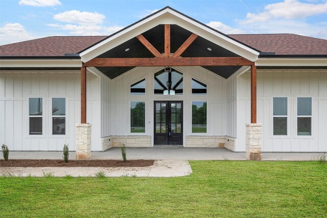 property entrance with a lawn, french doors, and roof with shingles