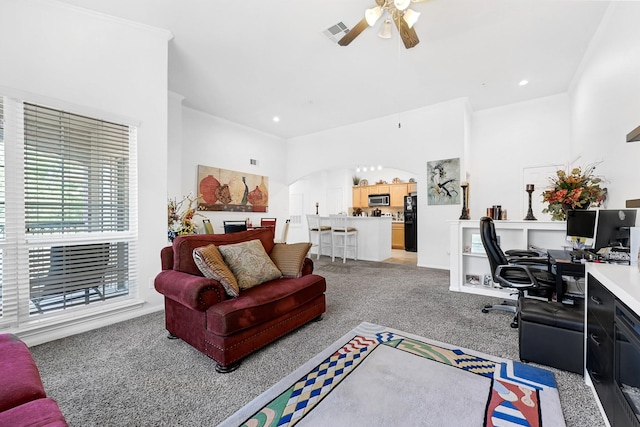 living area featuring visible vents, arched walkways, a ceiling fan, recessed lighting, and light carpet