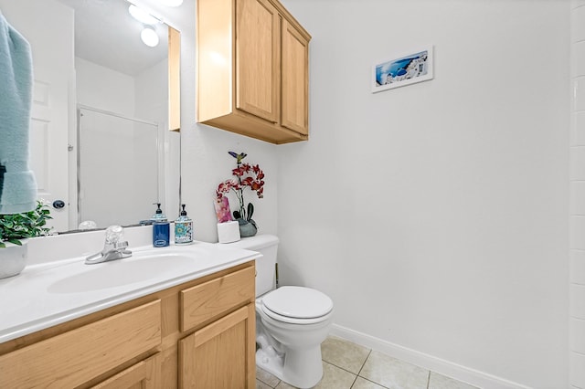 bathroom featuring vanity, tile patterned flooring, toilet, walk in shower, and baseboards