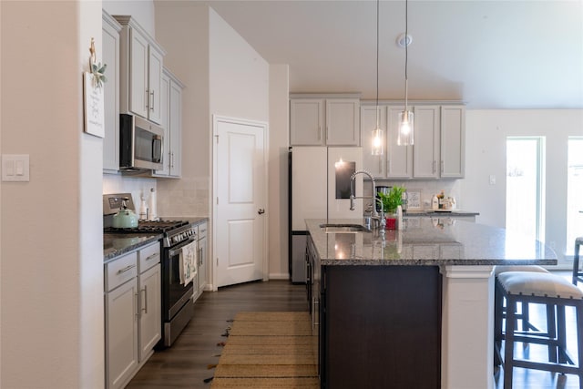 835 Sarasota Shore Dr, Katy, TX 77493 - kitchen with appliances with stainless steel finishes, a breakfast bar, tasteful backsplash, and dark wood-type flooring