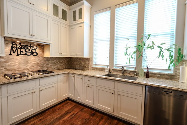 kitchen with glass insert cabinets, white cabinets, appliances with stainless steel finishes, dark wood-style flooring, and a sink