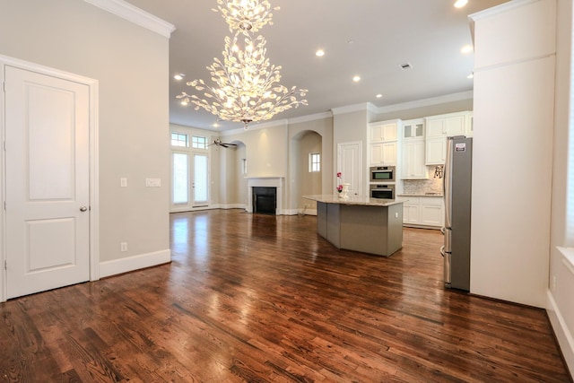 kitchen featuring a fireplace, open floor plan, white cabinetry, freestanding refrigerator, and backsplash