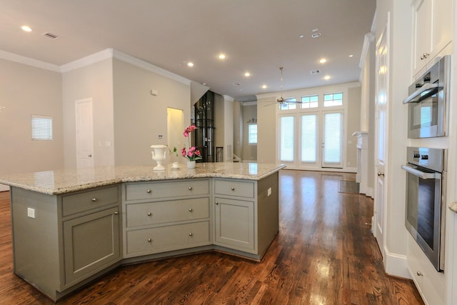kitchen with a ceiling fan, visible vents, gray cabinets, a center island, and dark wood-style floors