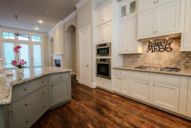 kitchen with arched walkways, dark wood-style flooring, white cabinetry, gray cabinetry, and stainless steel gas cooktop