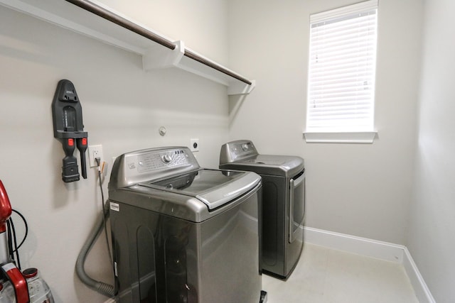 laundry room with laundry area, baseboards, and washer and clothes dryer