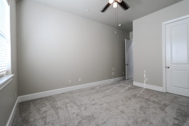 unfurnished bedroom with light colored carpet, baseboards, and a ceiling fan
