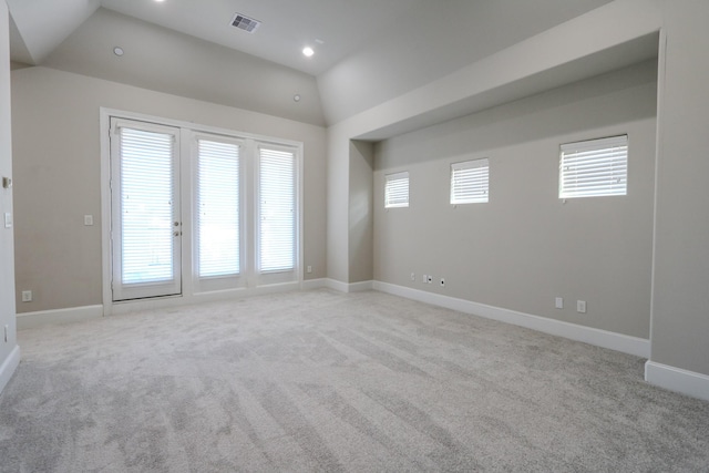 spare room with visible vents, baseboards, recessed lighting, vaulted ceiling, and light colored carpet