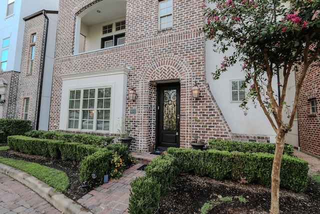 entrance to property with brick siding and stucco siding