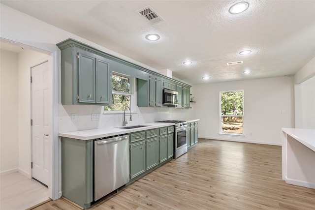 kitchen featuring a textured ceiling, green cabinets, appliances with stainless steel finishes, and visible vents