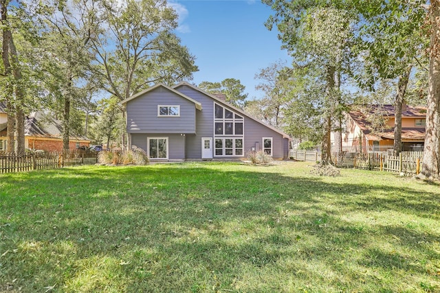 back of property with a lawn and a fenced backyard