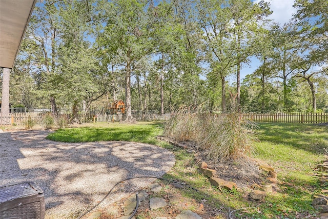 view of yard with a fenced backyard and a playground