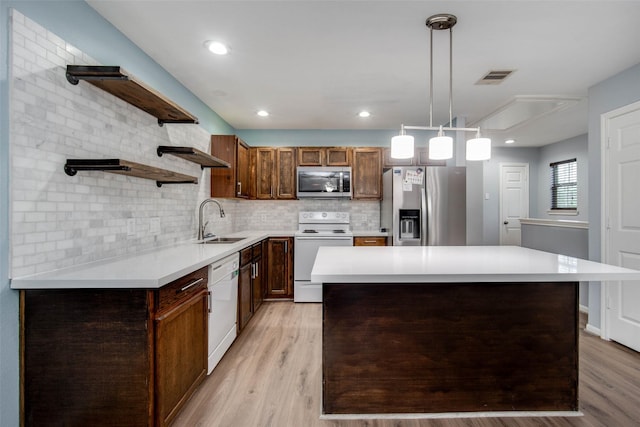 kitchen with open shelves, visible vents, light countertops, a sink, and stainless steel appliances