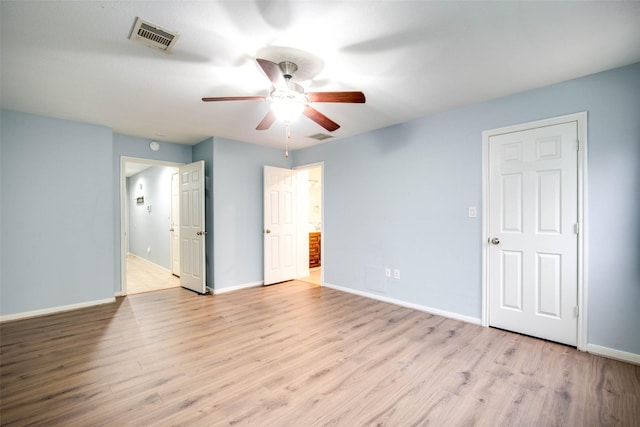 unfurnished bedroom featuring wood finished floors, baseboards, visible vents, and ensuite bath