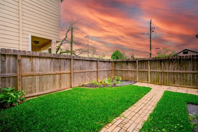 yard at dusk featuring a garden and fence private yard