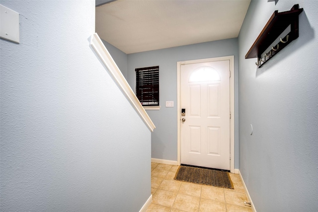 doorway to outside featuring light tile patterned flooring and baseboards