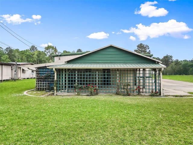 back of property with metal roof and a lawn