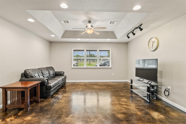 living area featuring concrete floors, visible vents, baseboards, and a raised ceiling