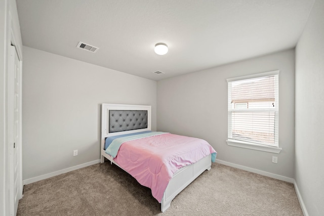 carpeted bedroom with visible vents and baseboards