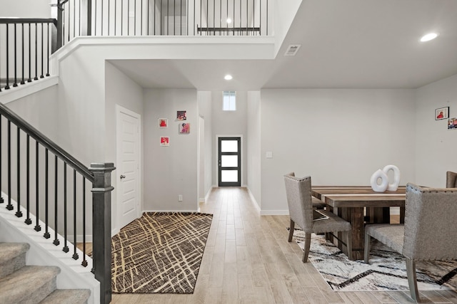 foyer featuring light wood finished floors, recessed lighting, visible vents, and stairs