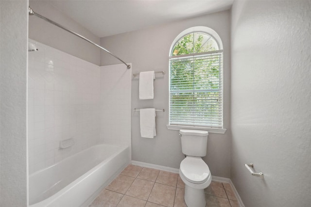bathroom featuring tile patterned floors, baseboards, washtub / shower combination, and toilet