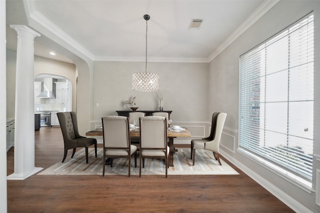 dining room featuring an inviting chandelier, visible vents, arched walkways, dark wood-type flooring, and crown molding